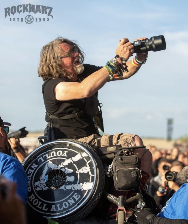 Björn vom Inklusionsteam des ROCKHARZ macht im Rollstuhl beim Crowdsurfen Fotos.